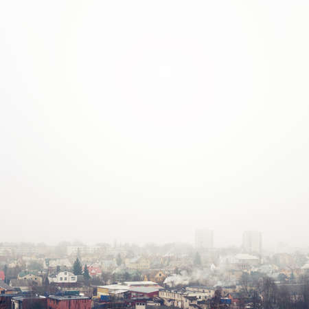 Small town cityscape background. Foggy weather, winter time.の写真素材