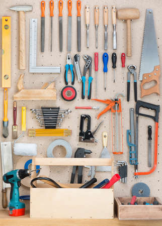 Various carpentry, construction tools hanging on the board.