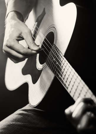 Guitarist playing acoustic guitar. Unplugged performance in the dark.の写真素材