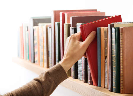 Hand taking book from the shelf.の写真素材