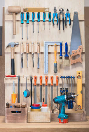 Garage tool rack with various tools and repair supplies on board .の写真素材