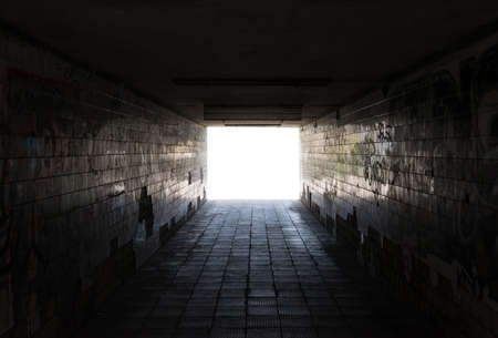 Underground passage. Old weathered dirty walls with graffiti.の写真素材
