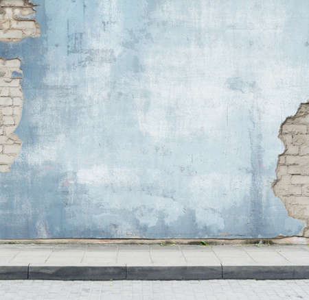 Urban background. Grunge obsolete street wall and pavement.の写真素材
