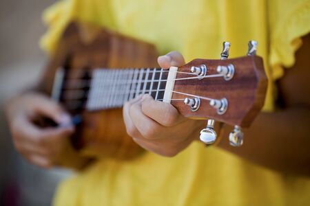 Details of teenage girl playing ukulele in summerの写真素材