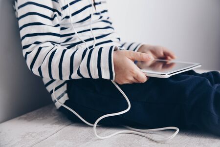 Child with tablet sitting on the floor. Technology concept. Connection concept. Internet addiction concept.の写真素材