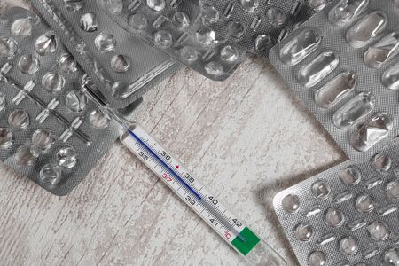 Empty blister of pills and thermometer close up