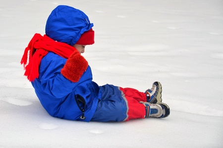 A child sitting quietly enjoying the snowy landscapeの写真素材