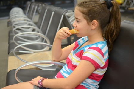 Girl at the airport - Young teenaged girl eating pizza while waiting for her flightの写真素材