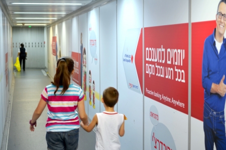 Two kids aged 12 and 6 boarding the airplane with Hebrew advertisements in the background at Tel Aviv Airport   TLV or Ben Gurion Airport  on August 18, 2013 in Tel Aviv, Israelのeditorial素材