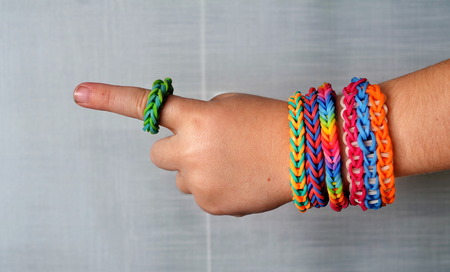 Little boy wearing colorful loom band rubber bracelets and ringの写真素材