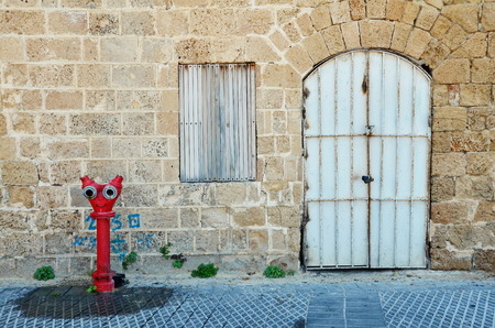 An alley with a fire hydrant, door, and window in the old city of Jaffa, Tel Aviv, Israelの写真素材