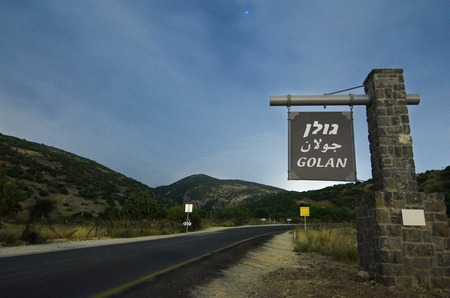 Star lighted road leading to the Golan Heights in Israel bordering Syria and Lebanon, with a sign welcoming visitors to the "Golan"の写真素材