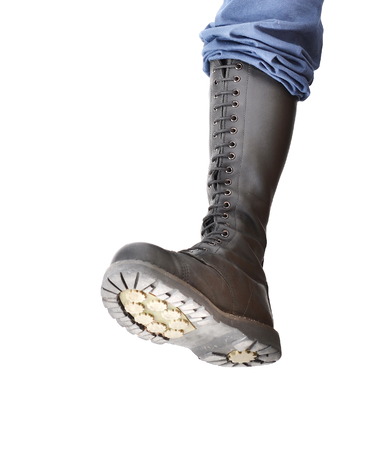 A tall lace-up combat boot stomping with the sole visibleの写真素材