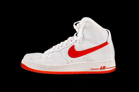 A high-top classic Nike AF-1 Air Force 1 white and orange leather basketball shoe sneaker, isolated on blackのeditorial素材