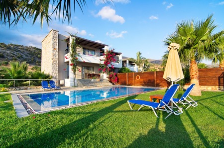 MALIA, GREECE - JULY 21, 2014: Villa with a private pool and garden on a summer vacation in golden hour light.  Malia, Crete near Hersonissos and Heraklion.のeditorial素材