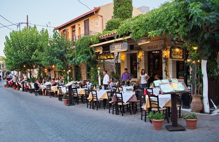 HERSONISSOS, GREECE - JULY 22, 2014: Creten Dinner Time - People eating dinner outdoors in Greek Tavernas at Hersonissos Old City Square in Crete, Greeceのeditorial素材