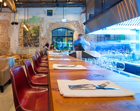 TEL AVIV, AUGUST 15, 2014: Patrons enjoying dinner in a modern open kitchen restaurant in Tel Aviv.  The restaurant is part of the hip Sarona district featuring restored Templer buildings.のeditorial素材