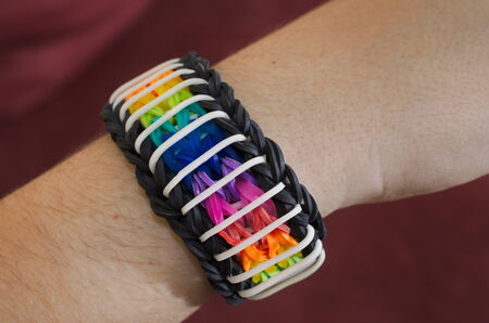 A child's hand decorated with rainbow color loom band rubber braceletの写真素材