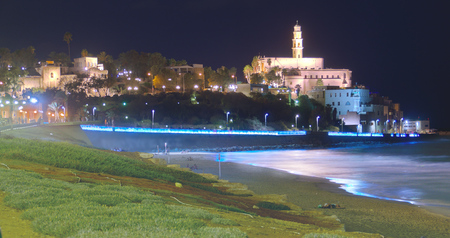 The famous Al-Barh mosque tower in Jaffa, Tel Aviv, Israel at night reflecting in the Mediterranean Seaの写真素材