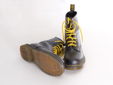 TEL AVIV, ISRAEL - SEPT 28, 2014: A pair of Doc Martens 8 eyelet 8 inch classic unisex black lace-up fashion combat boots with yellow laces and the sole visibleのeditorial素材