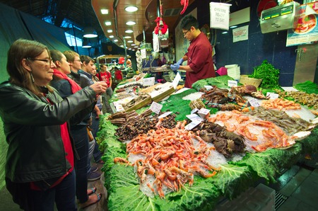 BARCELONA, SPAIN - OCT 14, 2014: People shopping for sea food in the in the famous Barcelona La Boqueria Market (Mercat de Sant Josep de la Boqueria) in Catalonia, Spainのeditorial素材