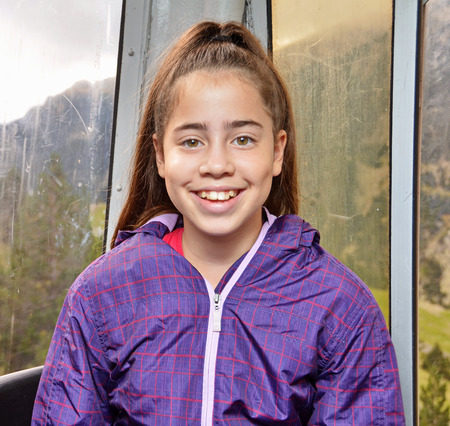Portrait of a 12 year old teenage girl having fun in a cable car while touring the Spanish Pyreneesの写真素材