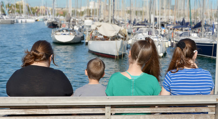 A family looking at the many sail boats anchored in Barcelona Port Harbor, Spainの写真素材