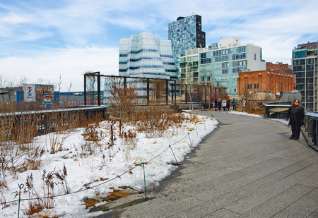 NEW YORK - MARCH 11, 2015: People walking the Manhattan New York High Line - a historic raised railroad track turned into a unique, modern public park winding between buildings and above the streetsのeditorial素材