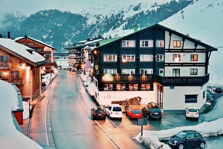 ZURS, AUSTRIA - APRIL 11, 2015: Evening in the hamlet of Zurs, part of the Arlberg Lech-Zurs ski resort.  Showing snow covered chalets, mountains, and ski pistes.のeditorial素材
