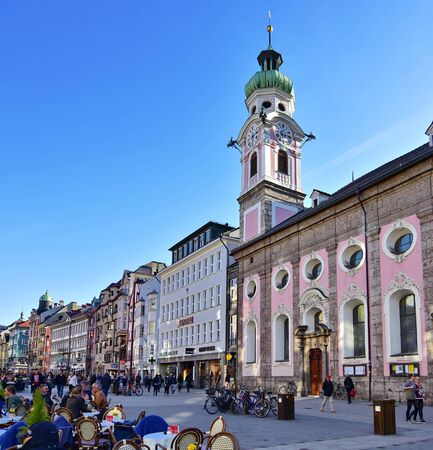 INNSBRUCK, AUSTRIA - APRIL 9, 2015: People enjoying one of the first spring days in the old alpine town of Innsbruck with views of snow capped mountains and historic architecture.のeditorial素材