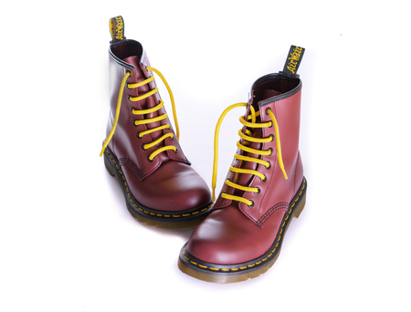 NEW YORK - OCT. 28, 2015: A pair of Doc Martens 8 eyelet 8 inch classic unisex cherry red oxblood lace-up fashion combat boots with yellow lacesのeditorial素材