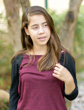 Teenage girl with orthodontic braces on her teeth enjoying the cool autumn weather outdoorの写真素材