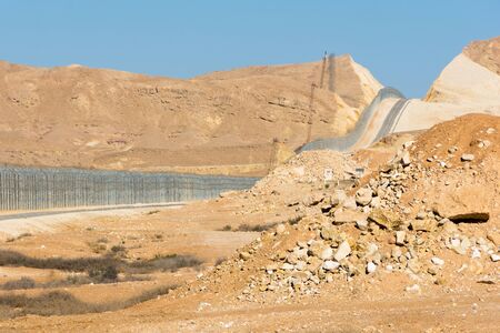 The new border fence between Israel (Negev Desert) and Egypt (Sinai Desert) with the patrol road protecting the borderの写真素材