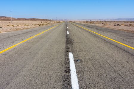 Lonely and empty desert road in the Southern Israel Negev Desert, between Mizpe Ramon and Eilatの写真素材
