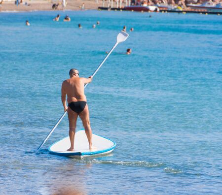 EILAT, ISRAEL - DEC. 29, 2016: Man on a SUP - like boat (called Hasake in Israel) in the Red Sea near the beach of sunny Eilat, Israelの写真素材
