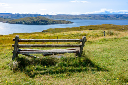 Old bench overlooking Loch Ewe and Isle of Ewe in Wester Ross, on the west coast of Scotland and the...