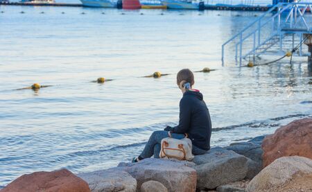 Young lady enjoying the sunset by the Red Sea beach of sunny Eilat, Israelの写真素材