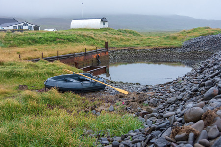 Dramatic beach of black pebbles, green grass, and lagoons on Skagafjordur, North Iceland during blue hour sunsetの写真素材