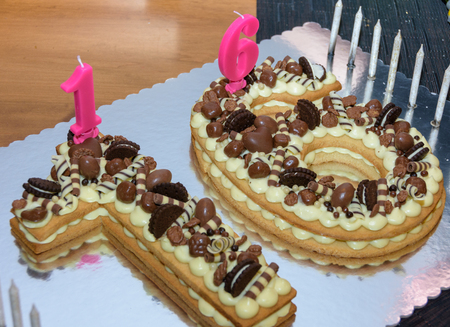 Original Sweet Sixteen birthday cake decorated with chocolate candies and candlesの写真素材