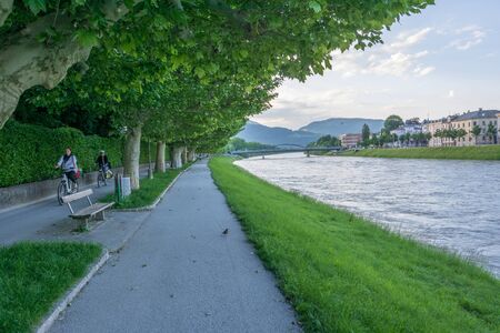 SALZBURG, AUSTRIA - JUNE 4, 2019: People biking and enjoying a warm spring day near the Salbach river in Salzburgの写真素材