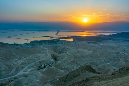 Panoramic sunrise on the Dead Sea in the south of Israel from the high altitude Dead Sea Lookout.  The sun is rising behind the Jordan Mountains.の写真素材