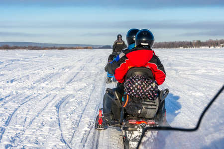 ROVANIEMI, FINLAND - FEB 27 2020: Tourists having a great time on snowmobiles in Laplandのeditorial素材
