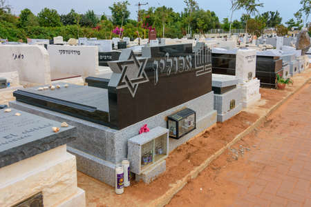 TEL AVIV - OCT. 26, 2019: Modern gravestones at  a Jewish cemetery in Israel at the outskirts of Tel Aviv.  Hebrew texts note the names and details of the deceased.のeditorial素材