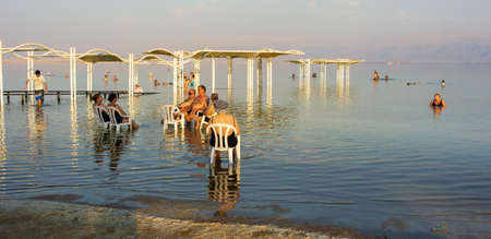 DEAD SEA, ISRAEL - OCT 13, 2019: Elderly people ejoying the warm waters of the Dead Sea at the evening golden hourのeditorial素材
