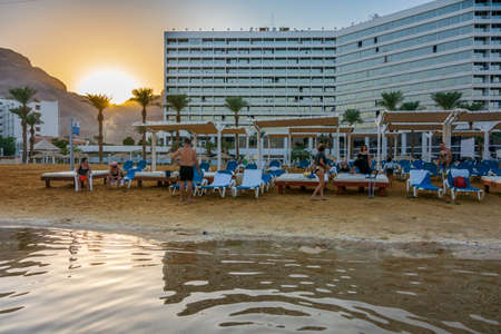 DEAD SEA, ISRAEL - OCT 13, 2019: People  ejoying the warm waters of the Dead Sea at Crown Plaza resort at the evening golden hourのeditorial素材