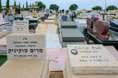 TEL AVIV - OCT. 26, 2019: Modern gravestones at  a Jewish cemetery in Israel at the outskirts of Tel Aviv.  Hebrew texts note the names and details of the deceased.のeditorial素材