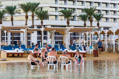 DEAD SEA, ISRAEL - OCT 13, 2019: Elderly people ejoying the warm waters of the Dead Sea at the evening golden hourのeditorial素材