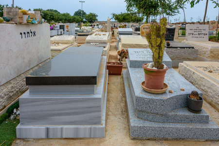 TEL AVIV - OCT. 26, 2019: Modern gravestones at  a Jewish cemetery in Israel at the outskirts of Tel Aviv.  Hebrew texts note the names and details of the deceased.のeditorial素材