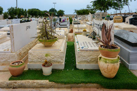 TEL AVIV - OCT. 26, 2019: Modern gravestones at  a Jewish cemetery in Israel at the outskirts of Tel Aviv.  Hebrew texts note the names and details of the deceased.のeditorial素材