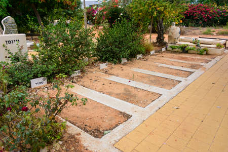 TEL AVIV - OCT. 26, 2019: Empty burial lots  at  a secular civil and Jewish cemetery in Israel at the outskirts of Tel Aviv.  Hebrew text says "reserved".のeditorial素材
